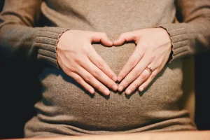 zwangere vrouw met handen op haar buik
