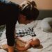 Moeder praat met haar baby op bed – vroege taalontwikkeling en zorg voor een gezonde start
